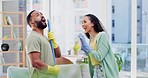 Cleaning, home and couple singing to music in living room with spray bottle, detergents and hygiene products. Relationship, housekeeping and happy man and woman clean, dancing and having fun together