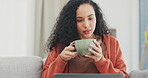 Woman, laptop and coffee on living room sofa, online shopping or social networking blog at home. Female, drinking and relax in lounge, computer and download media on website, internet or subscription