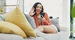 Happy woman wave on cellphone, video call and home for social network, virtual communication or online chat. Young female talking on smartphone in living room, sofa and hello to conversation on tech