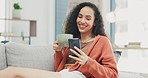 Laughing woman, coffee and smartphone on sofa in living room, social media and reading funny memes. Happy female relaxing on couch, cellphone and tea for texting, chat app and download mobile games 