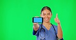 Green screen, phone and hands of doctor with thumbs up, point and advertising clinic mobile app mockup. Healthcare, digital and woman nurse on smartphone for wellness, medical service and telehealth