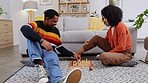 Chess, games and couple on floor in home playing board games for bonding, relax and quality time. Love, dating and happy black man and woman in living room having fun, problem solving and strategy