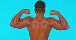 Body muscle, man back and studio with fitness and exercise of a bodybuilder. Isolated, blue background and strong arms of a male model with confidence and wellness with power and arm flexing