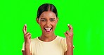 Hope, fingers crossed and woman in studio with green screen with a wish to win or success. Happy, smile and portrait of Indian female model with luck hand gesture isolated by a chroma key background.