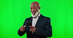 Green screen and black man pointing to phone in business news or communication isolated on studio background. Professional senior person with wow, success or notification on cellphone in mockup space