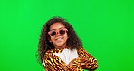 Green screen, sunglasses and face of child with costume, cool accessory and onesie with goofy smile. Halloween, studio and portrait of happy girl with crossed arms for comic, funny or emoji meme