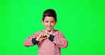 Heart, child and happy face with green screen and love emoji hand sign with a smile. Isolated, studio background and boy portrait with loving and care hands gesture with kids happiness smiling