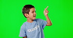 Pointing, volunteer and mockup with child in green screen studio for product placement, spa and idea. Positive, charity and help with young boy on background for show, support and suggestion