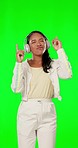 Music, green screen and woman with headphones, dance and celebration against a studio background. Female, lady and dancer with headset, movement and streaming with smile, listening and enjoy radio