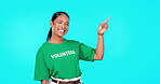 Volunteer, woman and point to empty space isolated on blue background text, product placement or advertising. Ngo, nonprofit and charity worker or biracial person face in studio, show or presentation