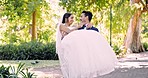 Love, wedding and a man carrying his wife outdoor in a garden on their marriage day celebration or ceremony. Happy, smile and a married couple in a park with a groom lifting his bride in tradition