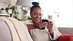 Black woman, phone and texting on a sofa with social media, app or online message in her home. Internet, meme and female relax in living room while reading, browsing and enjoy streaming subscription