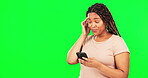 Phone, confused and mockup with a black woman on a green screen background in studio for communication. Mobile, contact and worry with a female feeling guilty while typing a text message on chromakey