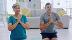 Yoga, meditation and couple in namaste in home living room for mindfulness. Meditate, prayer hands and senior man and woman in retirement to exercise or workout for calm, peace or zen chakra in house