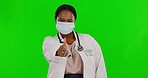 Green screen, doctor and black woman with mask, thumbs up and healthcare on a studio background. Portrait, female employee and medical professional with face cover, agreement and support regulations 