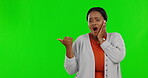 Wow, pointing and announcement with a woman on a green screen background in studio for advertising. Portrait, surprise and information with an african female on chromakey mockup for marketing