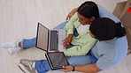 Couple, laptop and tablet on floor from above, checking internet for home renovation ideas. New homeowner, planning and online research for remodeling, man and woman sitting together reading website.