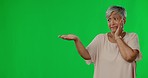 Elderly woman, open hand and space by green screen with fear, scared face and worry by background. Senior female, palm and mockup with stress, product placement and thinking with anxiety by backdrop