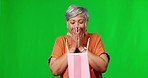 Happy, surprised and a woman with a gift on a green screen isolated on a studio background. Smile, birthday and an excited senior lady opening a present with shock and happiness on a backdrop