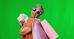 Happy woman, cash and shopping bags on green screen for fashion or purchase against a studio background. Portrait of stylish female with money fan and gift bag for buying luxury accessories on mockup