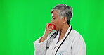 Doctor, thumbs up and apple portrait on green screen while happy and eating for healthy lifestyle. Happy healthcare worker on a diet for medical care, food nutrition and health on studio background