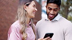 Phone, couple laughing and smile in city, social media or funny meme in urban street. Cellphone, happiness and interracial man and woman web browsing, internet scrolling or comedy, talking and comic.