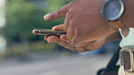 Closeup, outdoor and black man with smartphone, hands and typing with connection, social media and chatting. Hand, African American male outside and guy with cellphone, communication and mobile app