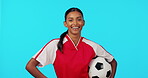 Sports, happy and soccer ball with woman in studio for fitness, training or competition. Smile, workout and football with portrait of female athlete on blue background for games, motivation and match