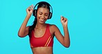 Woman dancer, headphones and fitness in studio with happiness, wellness and health by blue background. Gen z girl, athlete and audio hardware for music, streaming and workout for sport by backdrop