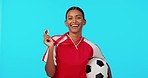 Sports winner, medal and excited woman with soccer player award, match competition victory or football achievement. Winning, studio celebration portrait and happy female athlete on blue background 