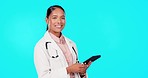 Happy, research and face of a doctor with a tablet isolated on a blue background in a studio. Smile, medical and a woman in healthcare working on tech for communication, schedule or reading results