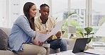 Laptop, couple talking and documents for finance, taxes or savings on sofa in home. Interracial, paperwork and black man and woman with computer for planning budget, insurance or financial bills.