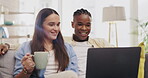 Laptop, coffee and couple talking in living room on home sofa, relax or online shopping. Computer, interracial and happiness of man and woman on couch internet browsing, social media or web scrolling