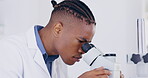 Science, microscope and research with a doctor man at work in a laboratory for innovation or breakthrough. Medical, sample and zoom with an african male scientist working in a lab for an experiment