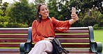 Selfie, smile and Asian woman on bench at park taking pictures for social media. Summer, profile picture and person sitting outdoor taking photo for happy memory, tongue out or funny face alone.