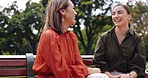 Women, friends and laughing at park on bench, bonding and talking together. Girls, outdoor and happiness of people in conversation, comic discussion or comedy and enjoying quality time for friendship