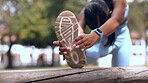 Stretching, legs and sports woman in park for muscle health, wellness and fitness training or cardio goals outdoor. Shoes, foot and athlete, runner or person warmup for workout or exercise in forest