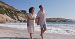 Walking, love and holding hands with couple at beach for travel, relax and summer vacation. Happy, relationship and romance with man and woman on date for bonding, affectionate and commitment