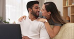 Couple, home and laptop while excited for working from home with internet connection. Young man and woman kiss and hug at computer with network for remote work or happy freelancing on lounge sofa