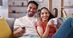 Remote control, relax and couple watching tv on a sofa, happy and laughing in their home together. Chilling, television and man with woman in living room for movie, streaming or subscription service