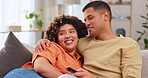 Film, love and entertainment with a couple watching tv on a sofa in the living room of their home together. Relax, video or television with a man and woman streaming series on a subscription service