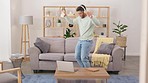 Man, dancing and listening to music in living room with headphones for fun, streaming or entertainment at home. Happy male with headset enjoying dance to audio track or sound in lounge on smartphone