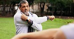 Fitness stretching, mature man and outdoor of an athlete with talking to personal trainer. Arm stretch, warm up and exercise of a male in a park for wellness and health with coaching discussion