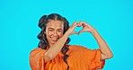 Smile, face and heart hands, woman on studio backdrop with mockup and freedom and support. Happy gen z model, love hand gesture and girl with creative lifestyle, kindness and care on blue background.