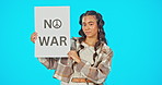 Portrait, poster and peace with a woman on a blue background in studio holding a no war sign. Freedom, human rights and politics with a young female activist at a rally to end conflict or fighting