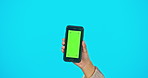 Phone, green screen and woman hand in studio advertising website, mobile app or network connection. Hands of gen z female model with smartphone for brand, social media or logo product placement
