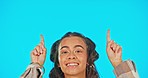 Woman, face and pointing, advertising with smile and product placement on blue background. Mockup space, portrait and playful female in studio, marketing and branding with logo promo, show or display
