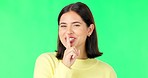 Wink, secret and face of a woman on a green screen isolated on a studio background. Quiet, silent and portrait of a winking girl with finger on mouth for silence, privacy and gossip on a backdrop
