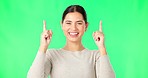 Smile, face and woman on green screen pointing up to news on mockup color background. Portrait of female model advertising promotion, product placement or presentation of commercial offer coming soon