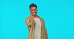 Face, man and pointing with thumbs up in studio isolated on a blue background. Portrait, product placement and Indian person showing advertising, marketing and mockup space, promotion or commercial.